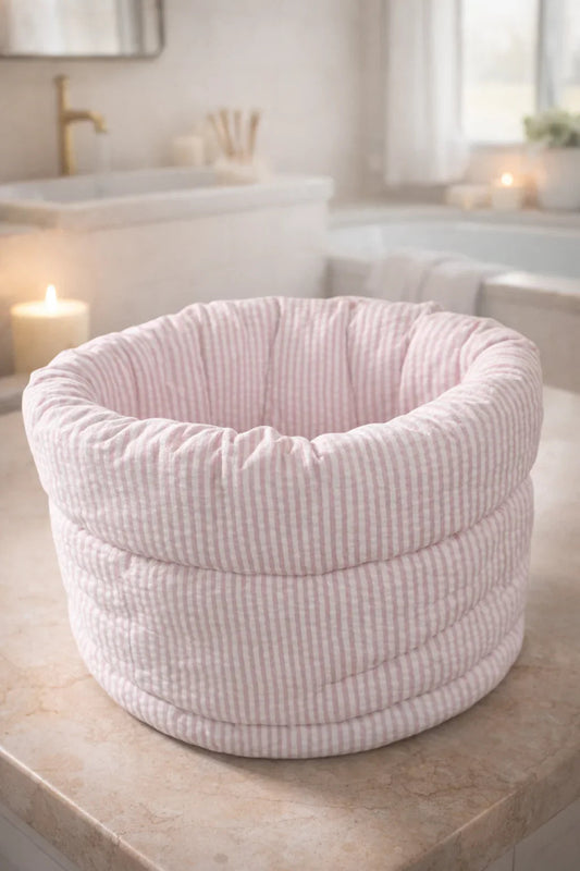 Pink quilted striped makeup organizer bucket bag on bathroom counter