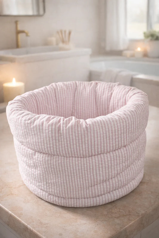 Pink quilted striped makeup organizer bucket bag on bathroom counter