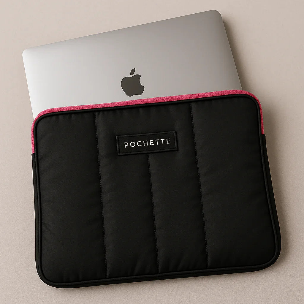 Quilted padded laptop sleeve in black with pink trim, holding a silver laptop