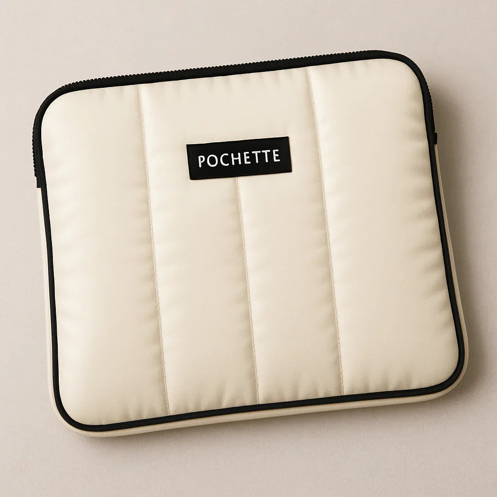 Beige quilted laptop case with black trim and padded sleeve on neutral background
