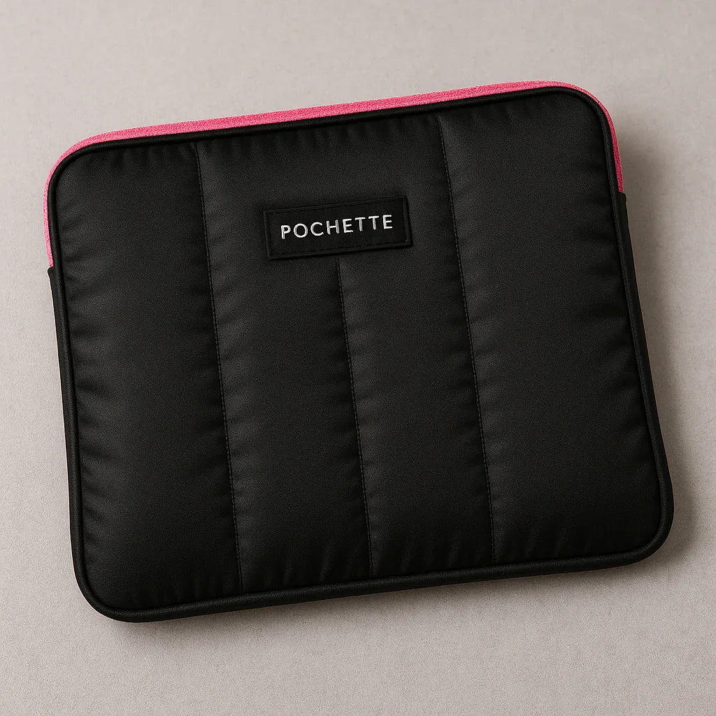 Black quilted laptop sleeve with padded texture and pink trim on a neutral background.