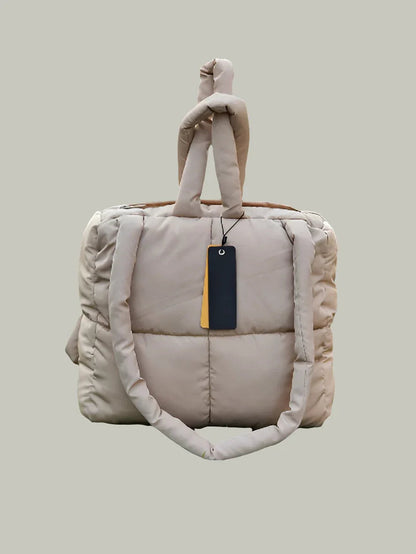 Beige quilted cotton beauty case with padded handles and product tag on neutral background