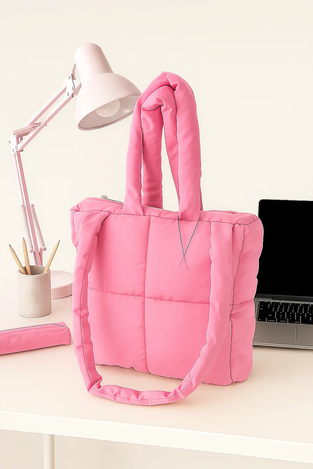 Handmade pink quilted cotton tote bag on a white desk with pink lamp and laptop