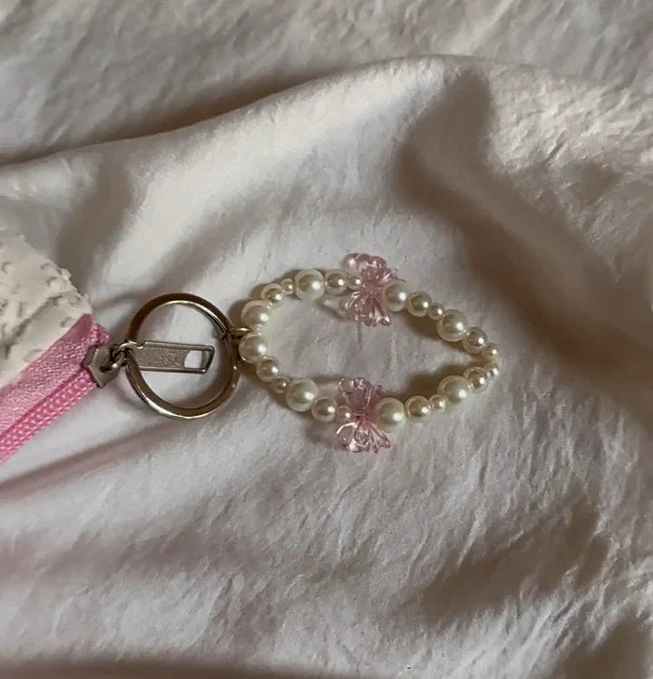 Pearl and pink butterfly beaded keychain on a white cotton beauty case with pink zipper